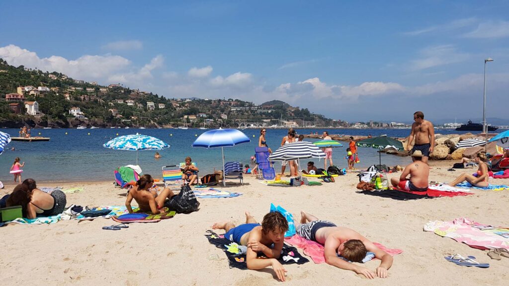 Plage de sable de La Napoule avec mer bleu clair et parasols