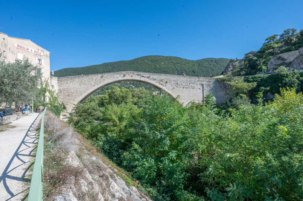 Pont Roman in Nyons, een historische stenen brug uit de 14e eeuw die hoog boven de rivier de Eygues loopt.