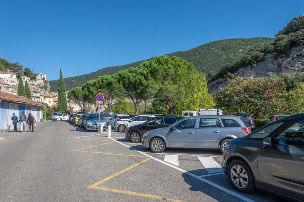 Parkeerplaats aan de rivier de Eygues in Nyons, met uitzicht op de omliggende heuvels en het historische centrum van het dorp.