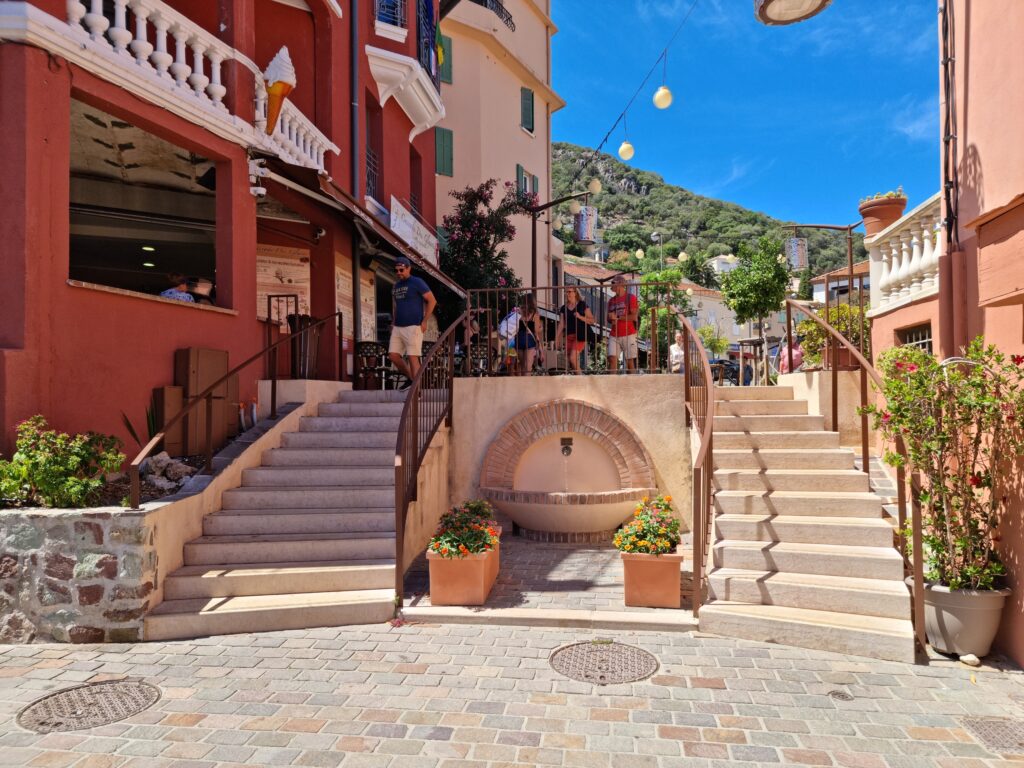 Centre of La Napoule with railway crossing and surrounding shops and terraces.