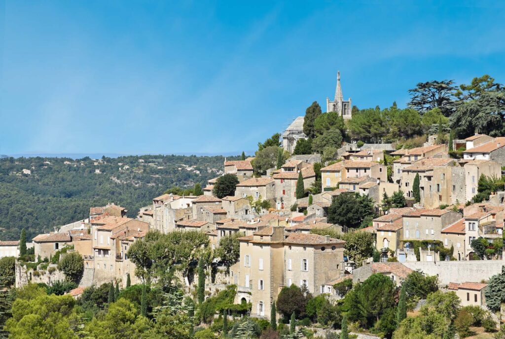 Panoramisch uitzicht op Bonnieux, genesteld in de heuvels van de Luberon, met historische gebouwen en een schilderachtig landschap.