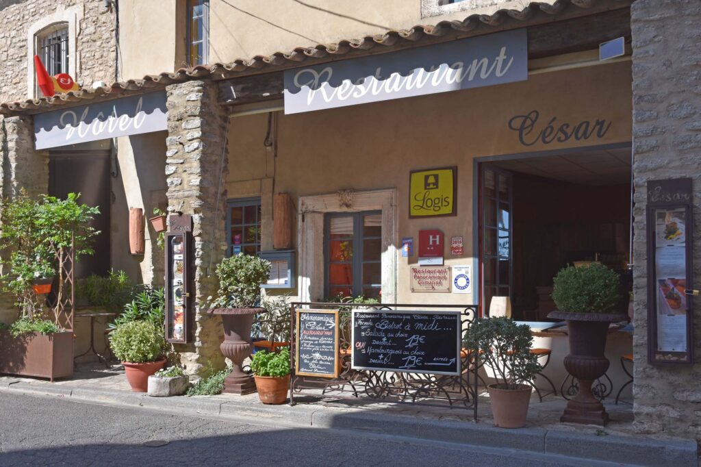 Gezellig restaurantje in Bonnieux met een sfeervolle gevel en een menukaart buiten op een bord.