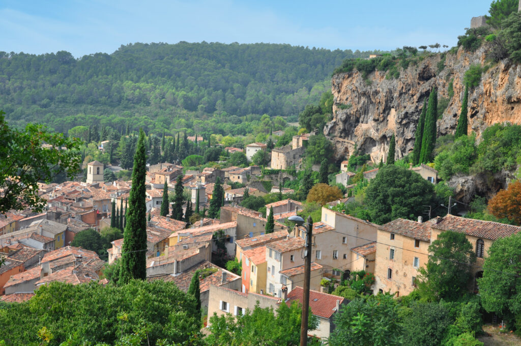 View of Cotignac with its high rock formations and the village below, photographed from a high vantage point