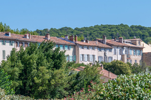 Panoramisch uitzicht op Lorgues met eeuwenoude architectuur, omgeven door groen en een heldere Provençaalse lucht.