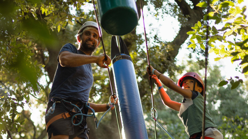 Accrobranche klimpark in Lorgues met een volwassene en kind die klimmen met veiligheidshelmen