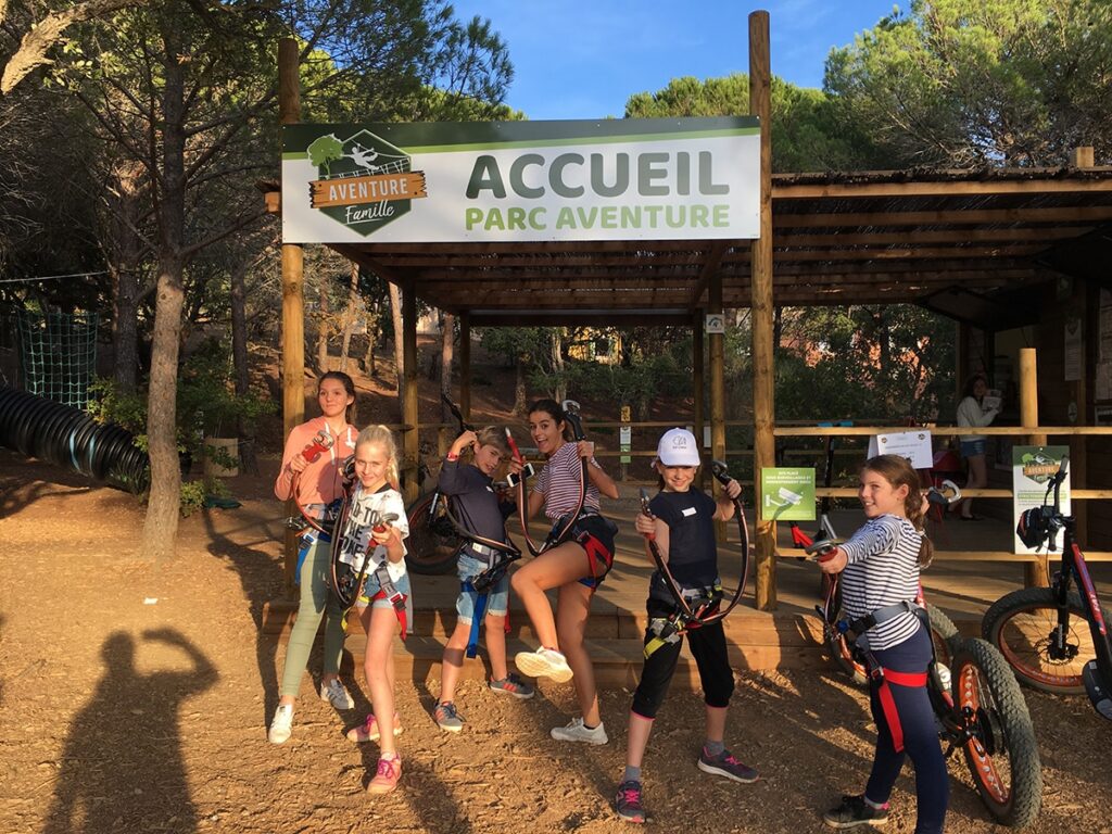 Ingang van het accrobranchepark in Sainte-Maxime met instructeurs en deelnemers voor het houten gebouwtje