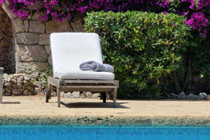 Ligbad naast het zwembad met bloeiende planten in een luxe villa aan de Côte d’Azur – zomerse sfeer en ontspanning.