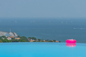 Zwembad met overloop en roze avondlicht, met uitzicht op de haven van Sainte-Maxime en de Middellandse Zee.