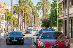 Centrum van Hyères met rijdende auto’s en een dubbele rij hoge palmbomen