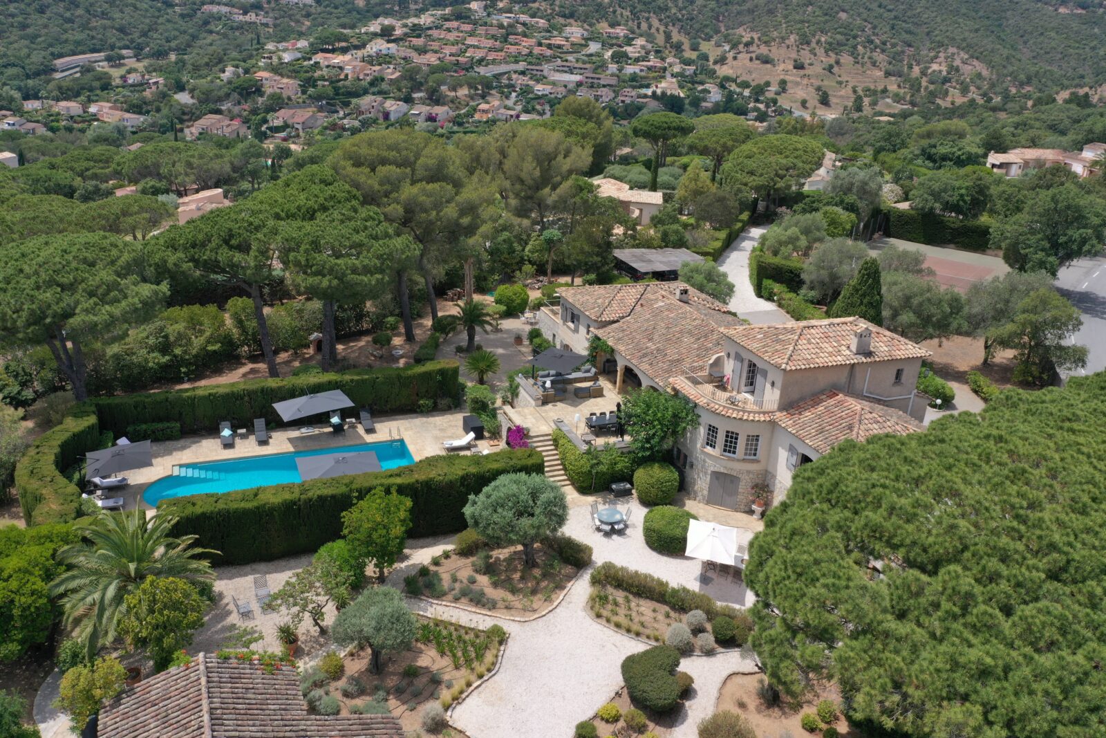Luchtfoto van Villa Toscane met zwembad, tuin, eigen tennisbaan en omringende natuur