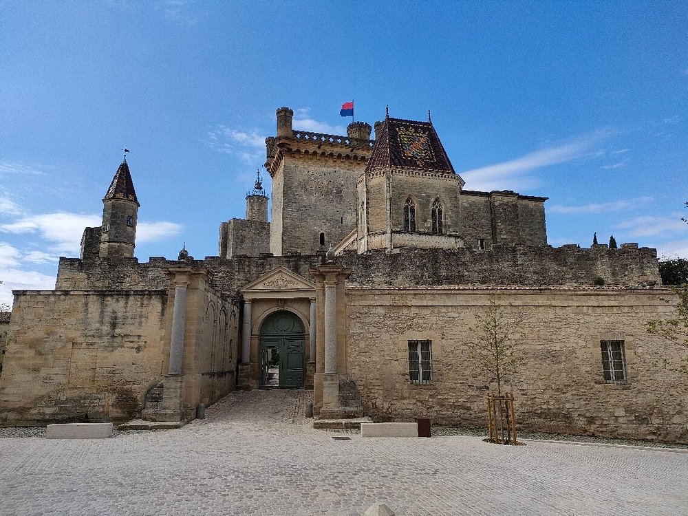 Het hertogelijk kasteel Duché d’Uzès, gefotografeerd vanaf het plein met zicht op de historische torens en gevels.